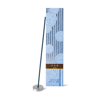 Vanilla incense sticks in a light blue box with foiled Japanese Zen stone garden patterns, with one stick propped on an aluminum incense holder in front of the box.