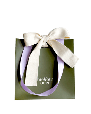 Olive green Mellover gift bag with subtle logo branding, lilac ribbon handle, and cream ribbon tie, designed for gifting home fragrance products.