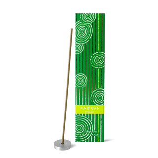 Bergamot incense sticks in a green and white box with foiled Japanese Zen stone garden patterns, with one stick propped on an aluminum incense holder in front of the box.
