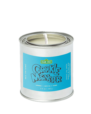 Limited edition Cookie Monster scented candle from the Sesame Street x Malathebrand collaboration, in a tin with 45-hour burn time and gourmand home fragrance.