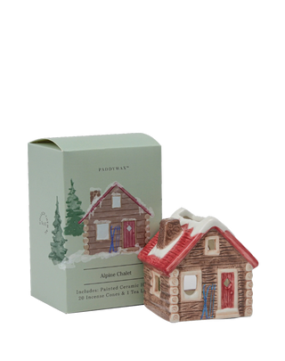 Paddywax Alpine Chalet ceramic incense house with snowy red roof and log cabin design, packaged in pastel green illustrated box, includes 20 incense cones and 1 tealight candle, cozy winter home fragrance décor.