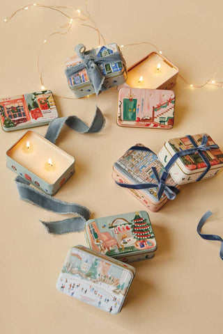 Paddywax Wassail holiday candle tin styled with festive décor and ribbon, cozy illustrated hallway and staircase scene evoking nostalgic Christmas warmth, ideal for gifting and home fragrance display.