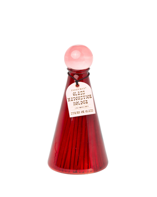 paddywax ruby glass bottle with light pink round cap filled with long matchsticks gold foiled label tied with black string decorative home accessory scented candles