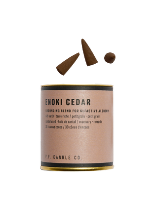 pf candle co enoki cedar incense cones from alchemy collection in gold tin with light brown label woody earthy home fragrance grounding and comforting meditative scent