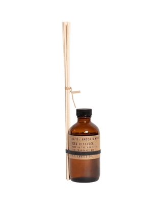 pf candle co amber moss reed diffuser in amber glass bottle with black cap and kraft paper label 3.5oz earthy fresh home fragrance relaxing sun kissed mountain inspired best selling scent