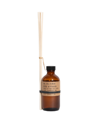 pf candle co pinon reed diffuser in amber glass bottle with black cap and kraft paper label 3 5oz woody home fragrance relaxing pine forest inspired scent